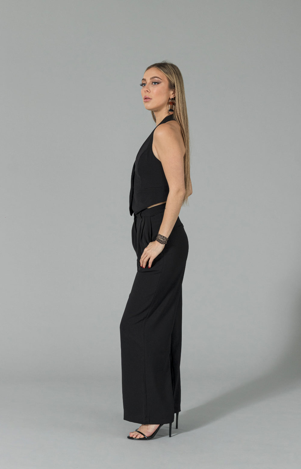 Introducing our Mia halter neck vest, perfect for any occasion! This stylish halter top features buttons at the center front, adding a unique touch to the design. Whether you're dressing up for a night out or keeping it casual for a day at the office, this versatile vest top has got you covered. Its halter style neckline adds a touch of elegance, making it a must-have item for your wardrobe.