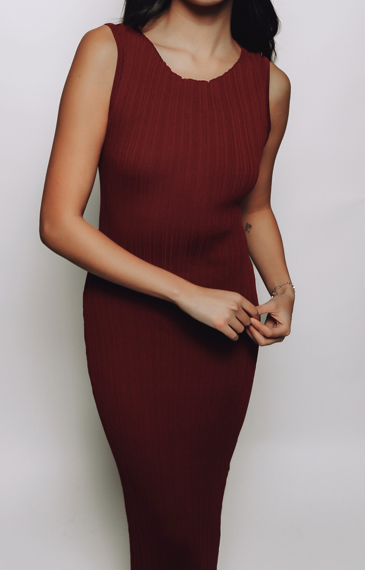 The Celia Patterned Rib Maxi Dress showcases a stunning burgundy hue with a subtle, textured pattern woven into the stretchy ribbed fabric. This elegant maxi dress is perfect for any occasion, offering a sophisticated silhouette that blends comfort with timeless style.