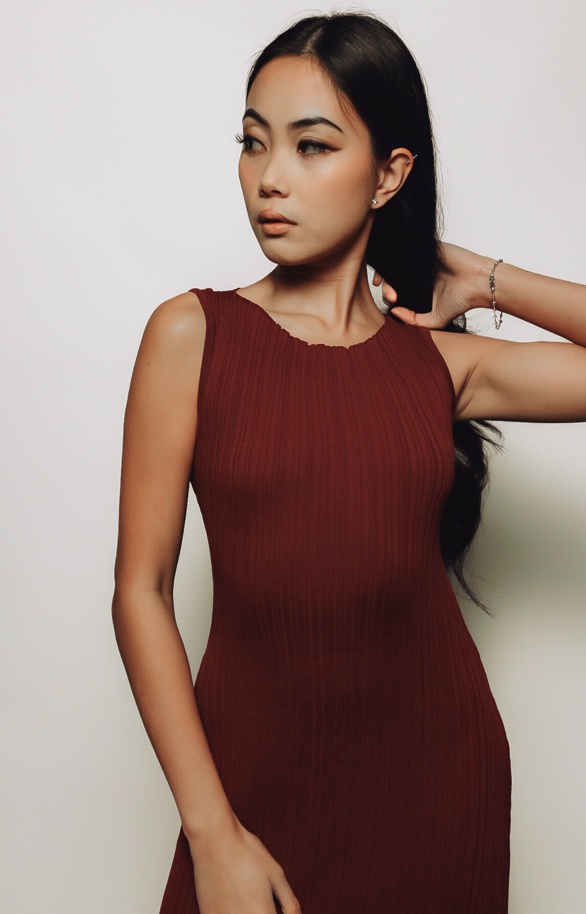 The Celia Patterned Rib Maxi Dress showcases a stunning burgundy hue with a subtle, textured pattern woven into the stretchy ribbed fabric. This elegant maxi dress is perfect for any occasion, offering a sophisticated silhouette that blends comfort with timeless style.