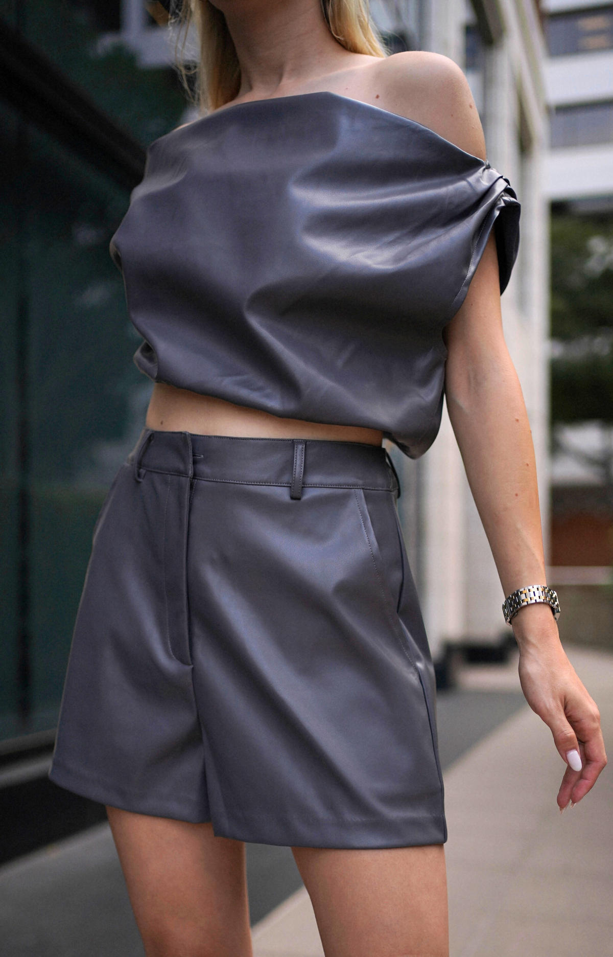Elevate your look with the Gina Faux Leather Top. This chic top features a stylish draped shoulder design and an elastic hem for a comfortable fit. Crafted from high-quality faux leather, this faux leather top perfect for any occasion. Pair it with the Gina Faux Leather Shorts for a complete, fashionable ensemble that exudes confidence and flair.