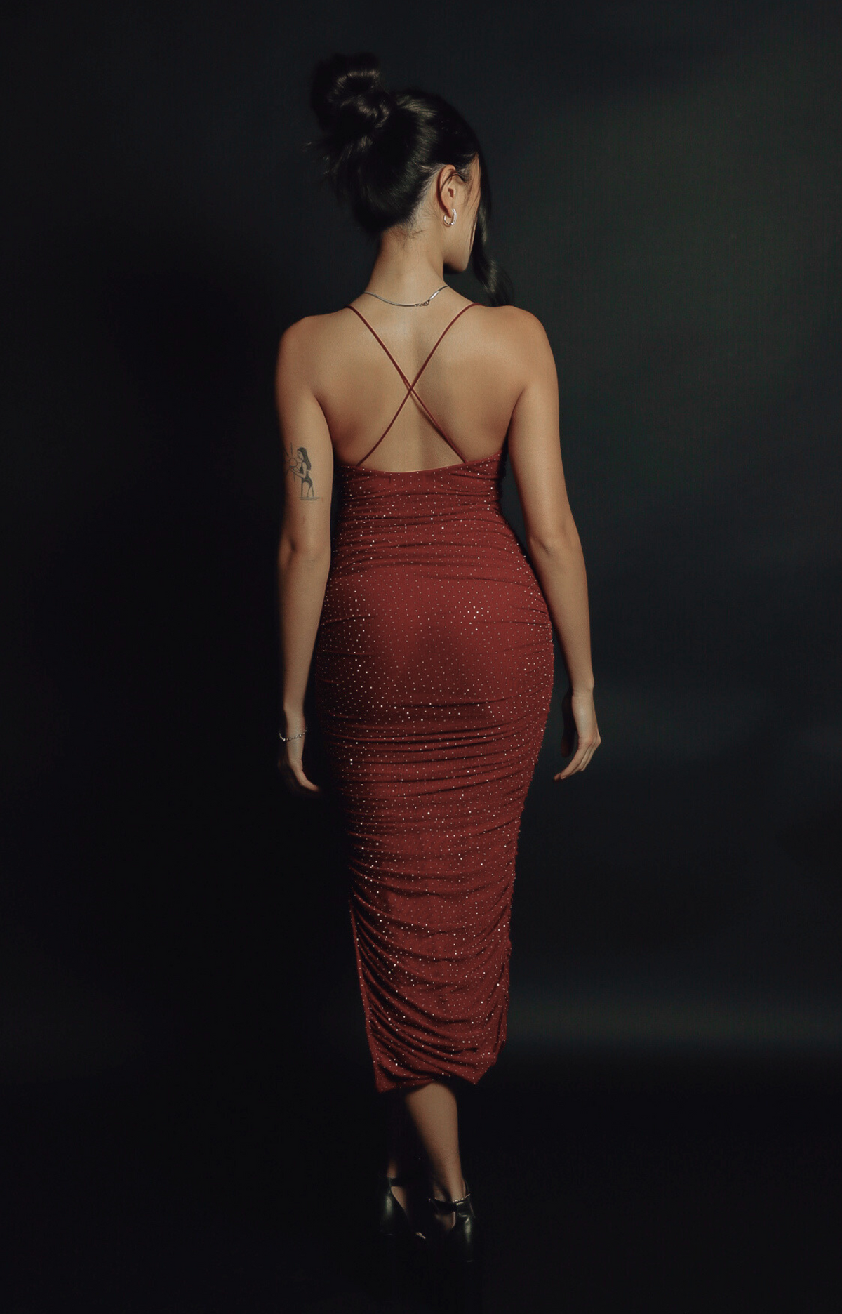 Turn heads in the Kelly Crystal Ruched Midi Dress, a show-stopping piece with sparkling crystal details and a stunning criss-cross back strap design. The flattering ruched silhouette, combined with soft, stretchy fabric, creates an elegant and glamorous look perfect for special occasions. Dazzle with every step in this gorgeous midi dress.