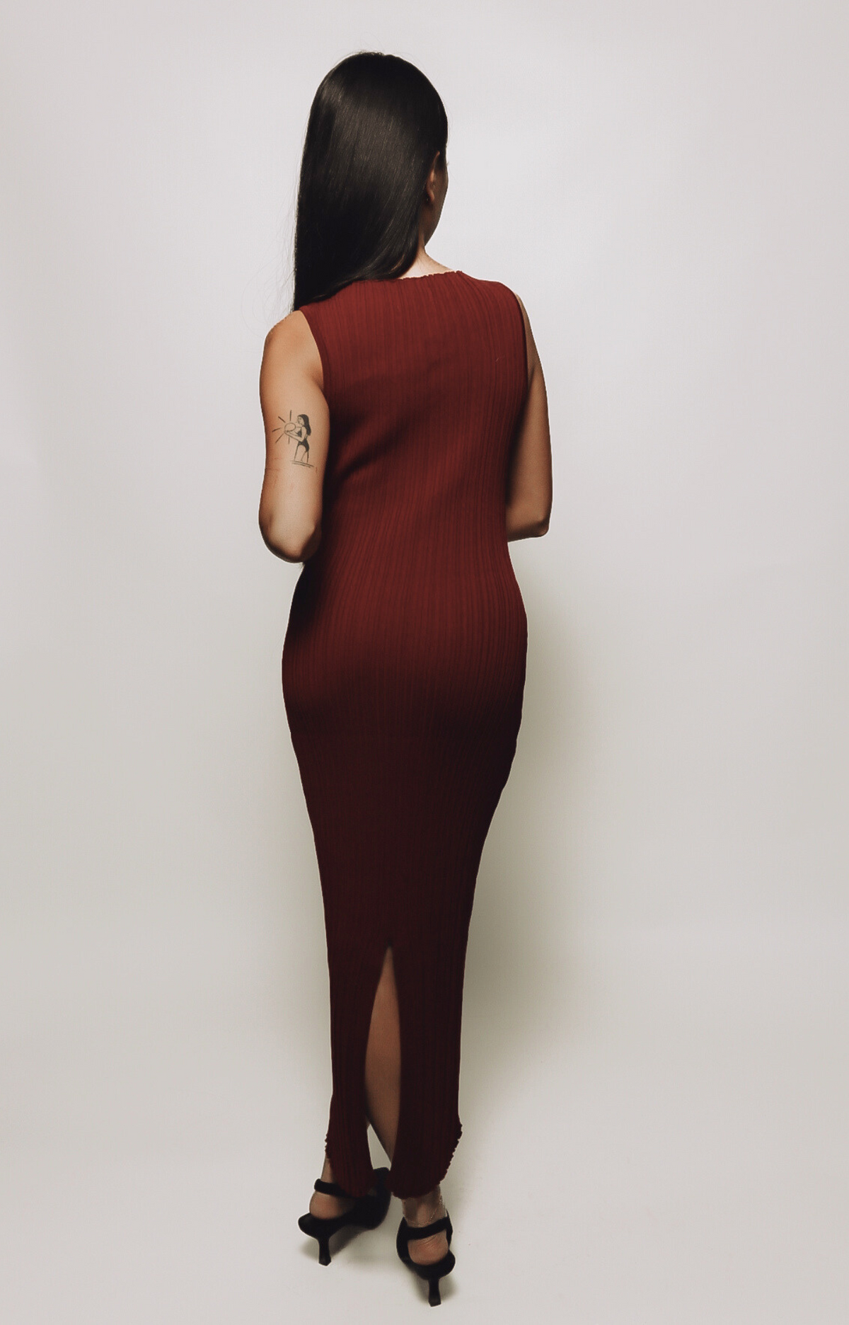 The Celia Patterned Rib Maxi Dress showcases a stunning burgundy hue with a subtle, textured pattern woven into the stretchy ribbed fabric. This elegant maxi dress is perfect for any occasion, offering a sophisticated silhouette that blends comfort with timeless style.