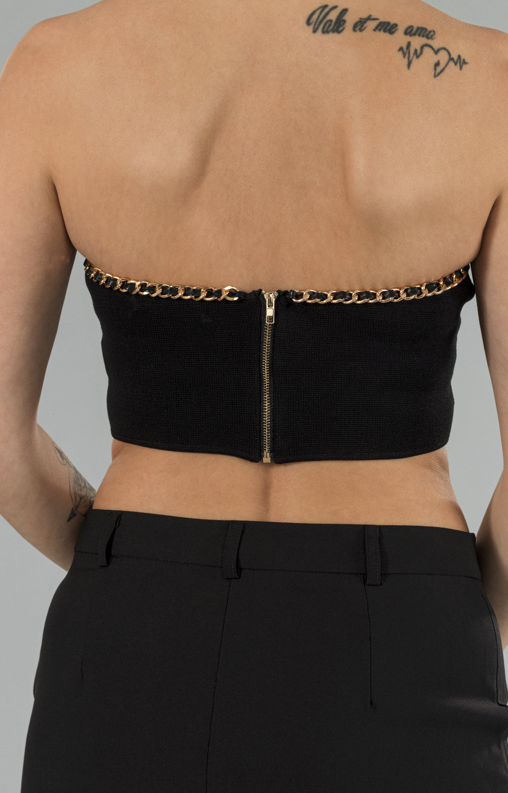 Introducing our stunning Jenna crop top, designed to add a touch of elegance to any outfit. This eye-catching piece features a beautiful gold chain detail around the neckline, adding a luxurious touch to the overall design. The zipper at the center back ensures a perfect fit, while the stretchy fabric provides ultimate comfort. Versatile and stylish, this chain crop top is perfect for any occasion, whether it's a night out or a casual day out with friends.