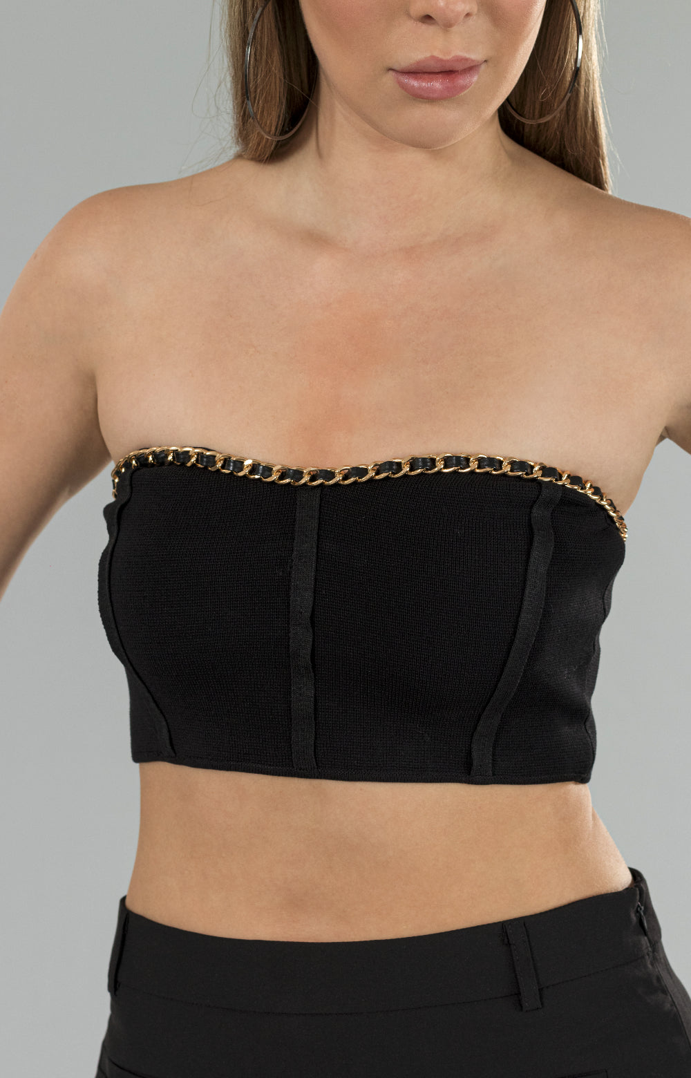 Introducing our stunning Jenna crop top, designed to add a touch of elegance to any outfit. This eye-catching piece features a beautiful gold chain detail around the neckline, adding a luxurious touch to the overall design. The zipper at the center back ensures a perfect fit, while the stretchy fabric provides ultimate comfort. Versatile and stylish, this chain crop top is perfect for any occasion, whether it's a night out or a casual day out with friends. 