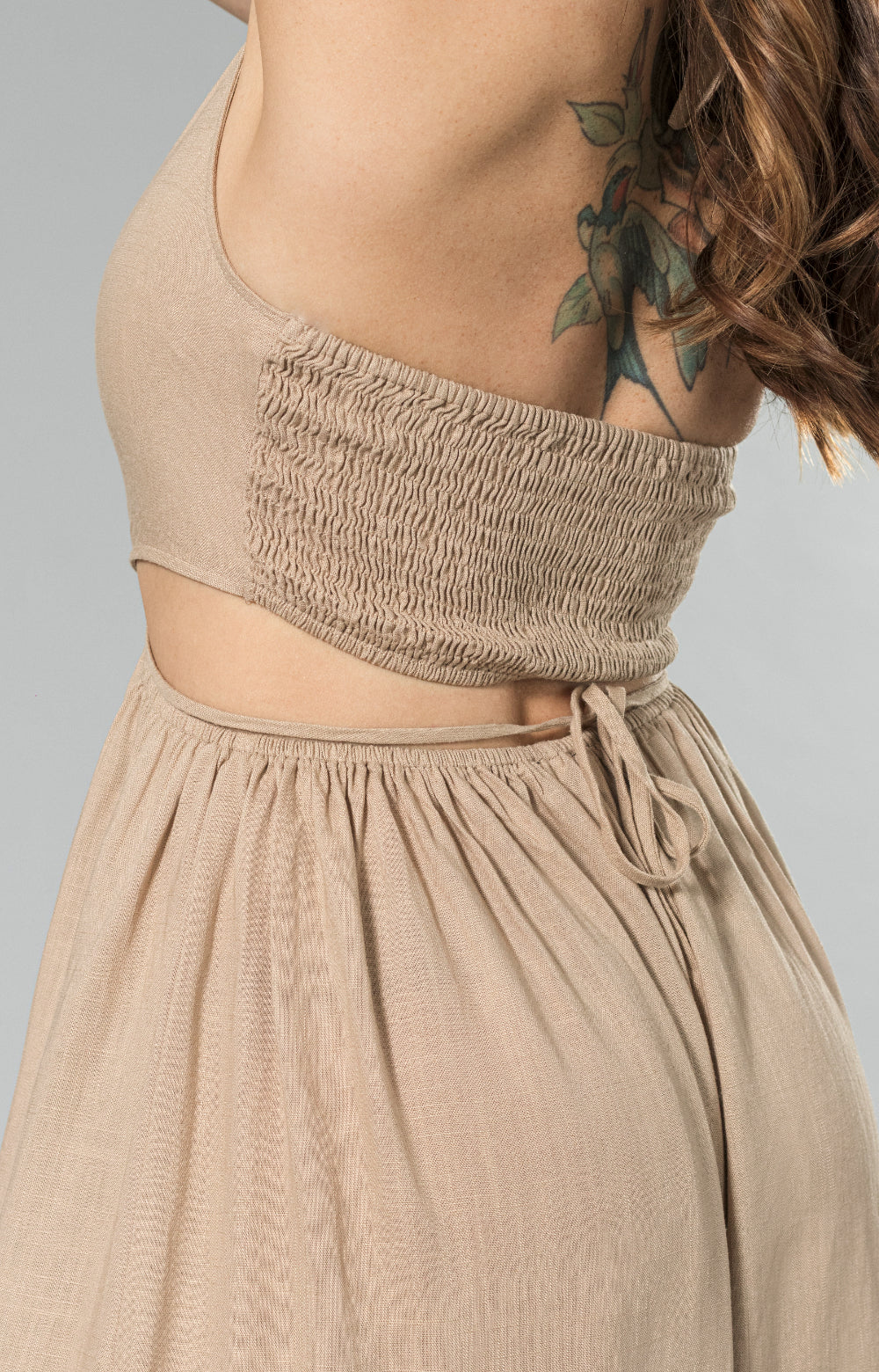 Get ready to turn heads in our stylish Sahara linen wide leg jumpsuit. Made from lightweight and breathable linen blend fabric, this halter neck jumpsuit features a wide leg capri design, back smocking for a comfortable fit, and a waist tie to enhance your figure. The halter cut out detail adds a playful touch, making it the perfect choice for any occasion. 

