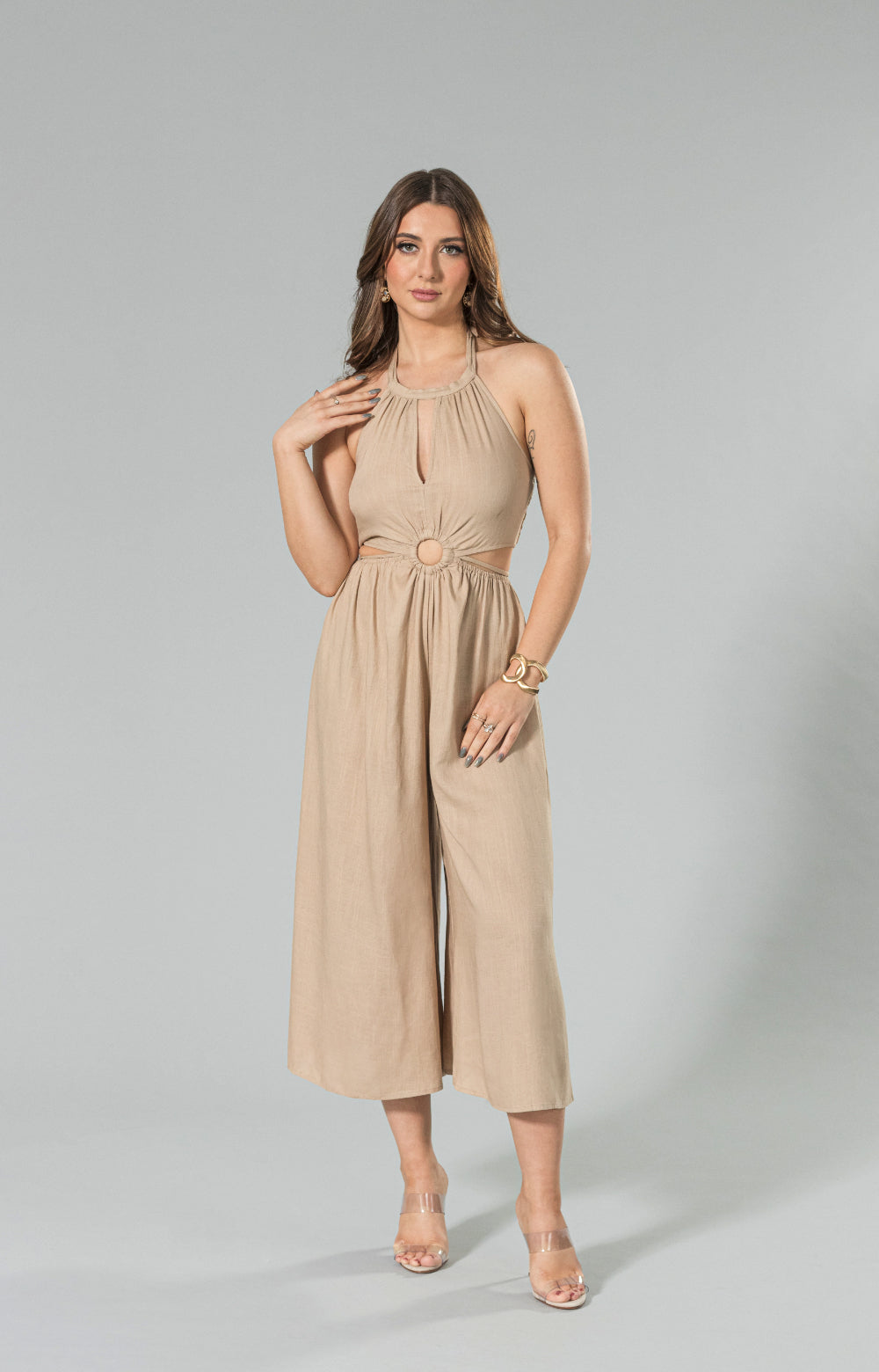 Get ready to turn heads in our stylish Sahara linen wide leg jumpsuit. Made from lightweight and breathable linen blend fabric, this halter neck jumpsuit features a wide leg capri design, back smocking for a comfortable fit, and a waist tie to enhance your figure. The halter cut out detail adds a playful touch, making it the perfect choice for any occasion. 

