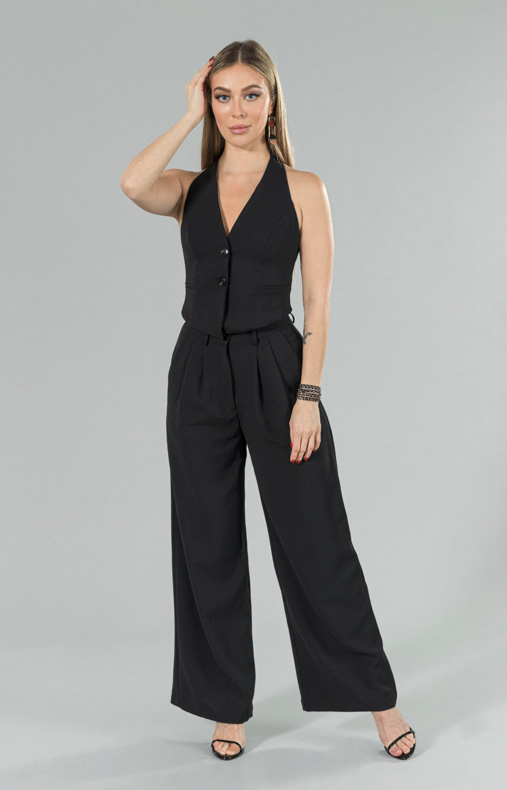 Introducing our Mia halter neck vest, perfect for any occasion! This stylish halter top features buttons at the center front, adding a unique touch to the design. Whether you're dressing up for a night out or keeping it casual for a day at the office, this versatile vest top has got you covered. Its halter style neckline adds a touch of elegance, making it a must-have item for your wardrobe.
