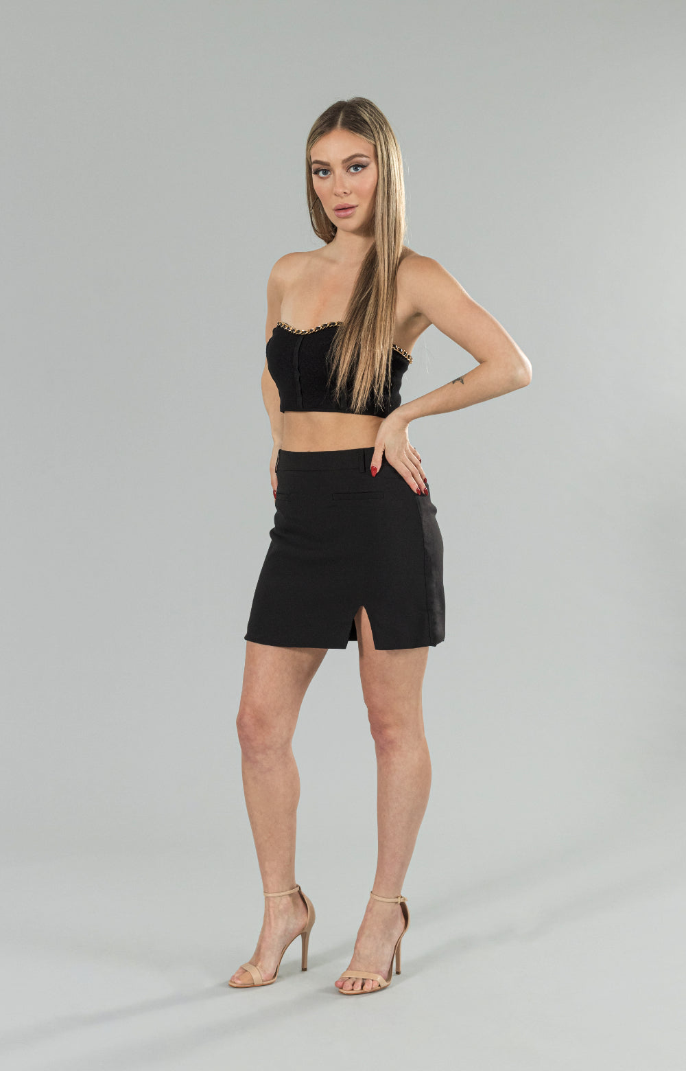 Introducing our Donna black skirt with a stylish twist! This elegant skirt features a subtle slit on the side, adding a touch of sophistication to your wardrobe. Made from high-quality materials, it offers a great fit that will flatter your figure beautifully. The side invisible zipper ensures a seamless and smooth look, without compromising on comfort. Perfect for any occasion, whether it's a night out with friends or a formal event, this black skirt with slit is a must-have addition to your closet.&nbsp;