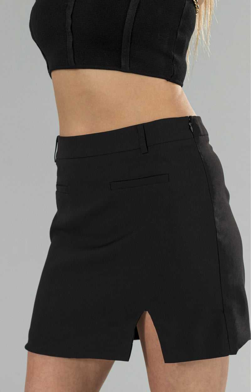Introducing our Donna black skirt with a stylish twist! This elegant skirt features a subtle slit on the side, adding a touch of sophistication to your wardrobe. Made from high-quality materials, it offers a great fit that will flatter your figure beautifully. The side invisible zipper ensures a seamless and smooth look, without compromising on comfort. Perfect for any occasion, whether it's a night out with friends or a formal event, this black skirt with slit is a must-have addition to your closet.&nbsp;